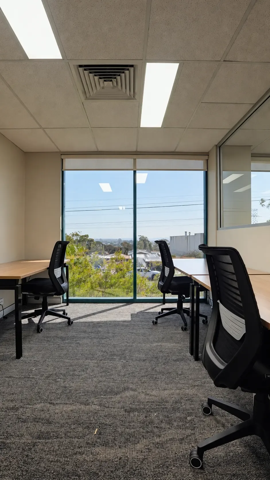 Desks facing a wide window over Kirrawee at Local Hubb