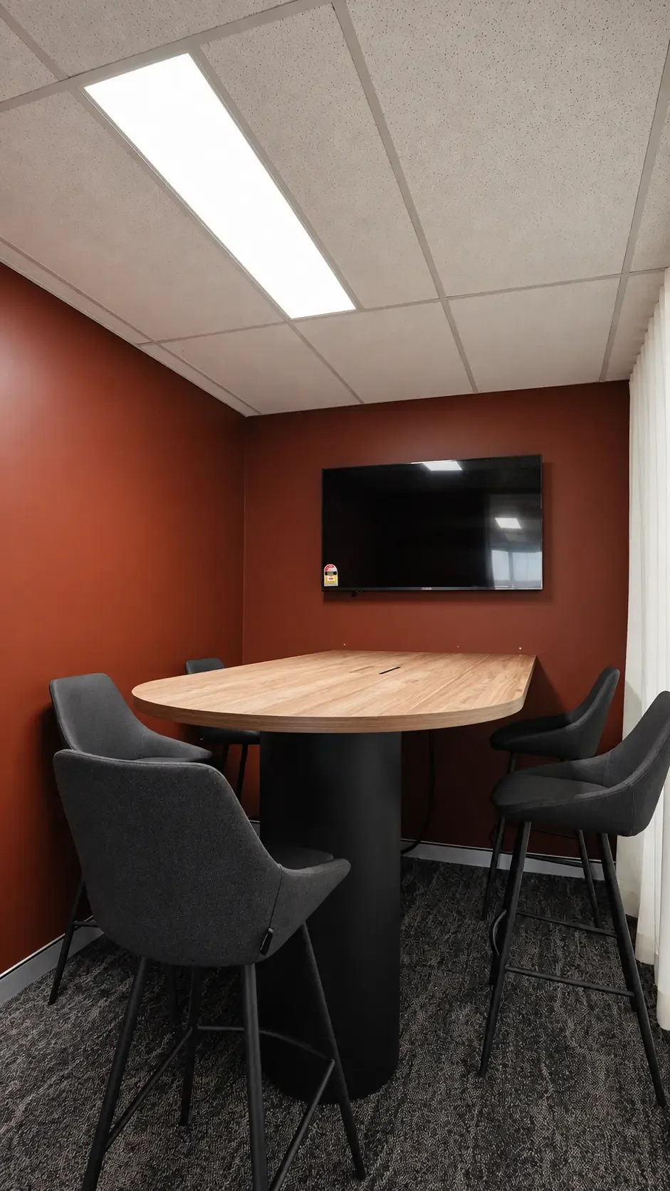 Meeting room with terracotta feature wall, high table and screen